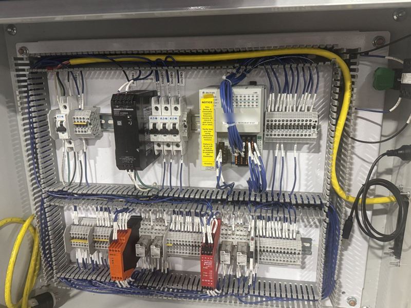 Control panel: Allen-Bradley CompactLogix, Eaton breakers and a safety relay, every wire labeled and run in duct